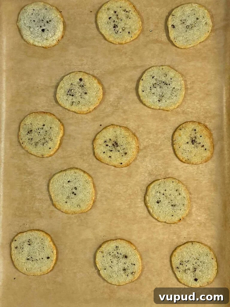 Crispy Blue Cheese Crackers: Homemade Savory Wafers Recipe 10 Baked blue cheese wafers on a parchment paper lined baking sheet.