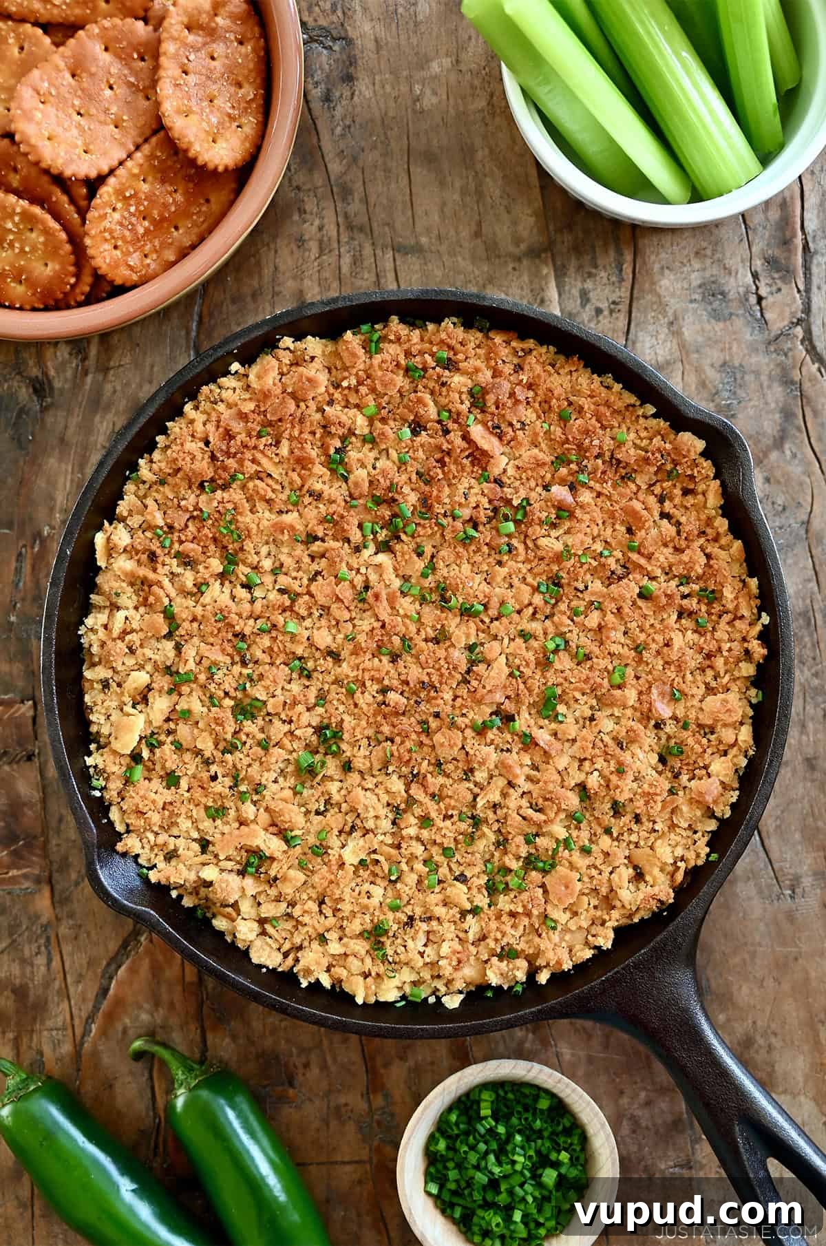 Creamy Jalapeño Popper Dip Recipe for Parties and Game Day 11 Jalapeño popper dip with a crunchy cracker topping in a cast-iron skillet.