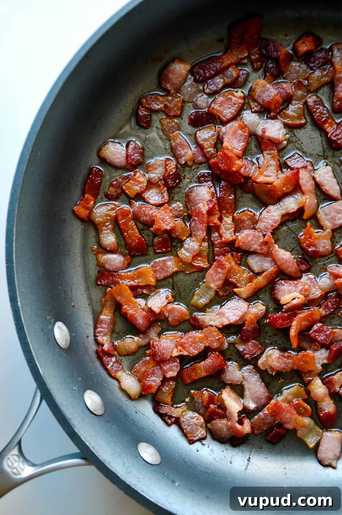 Creamy Jalapeño Popper Dip Recipe for Parties and Game Day 4 Rendered bacon pieces in a nonstick skillet.