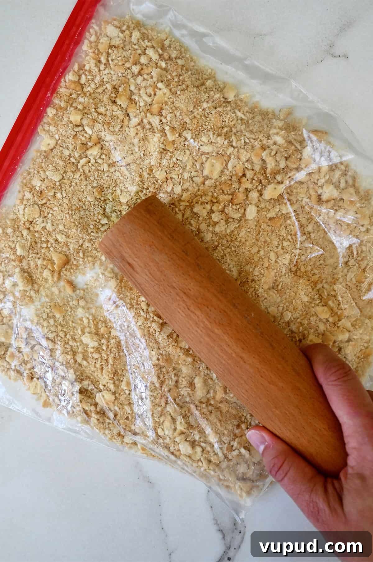 Creamy Jalapeño Popper Dip Recipe for Parties and Game Day 6 Using a rolling pin to crush crackers in a sealed plastic bag.