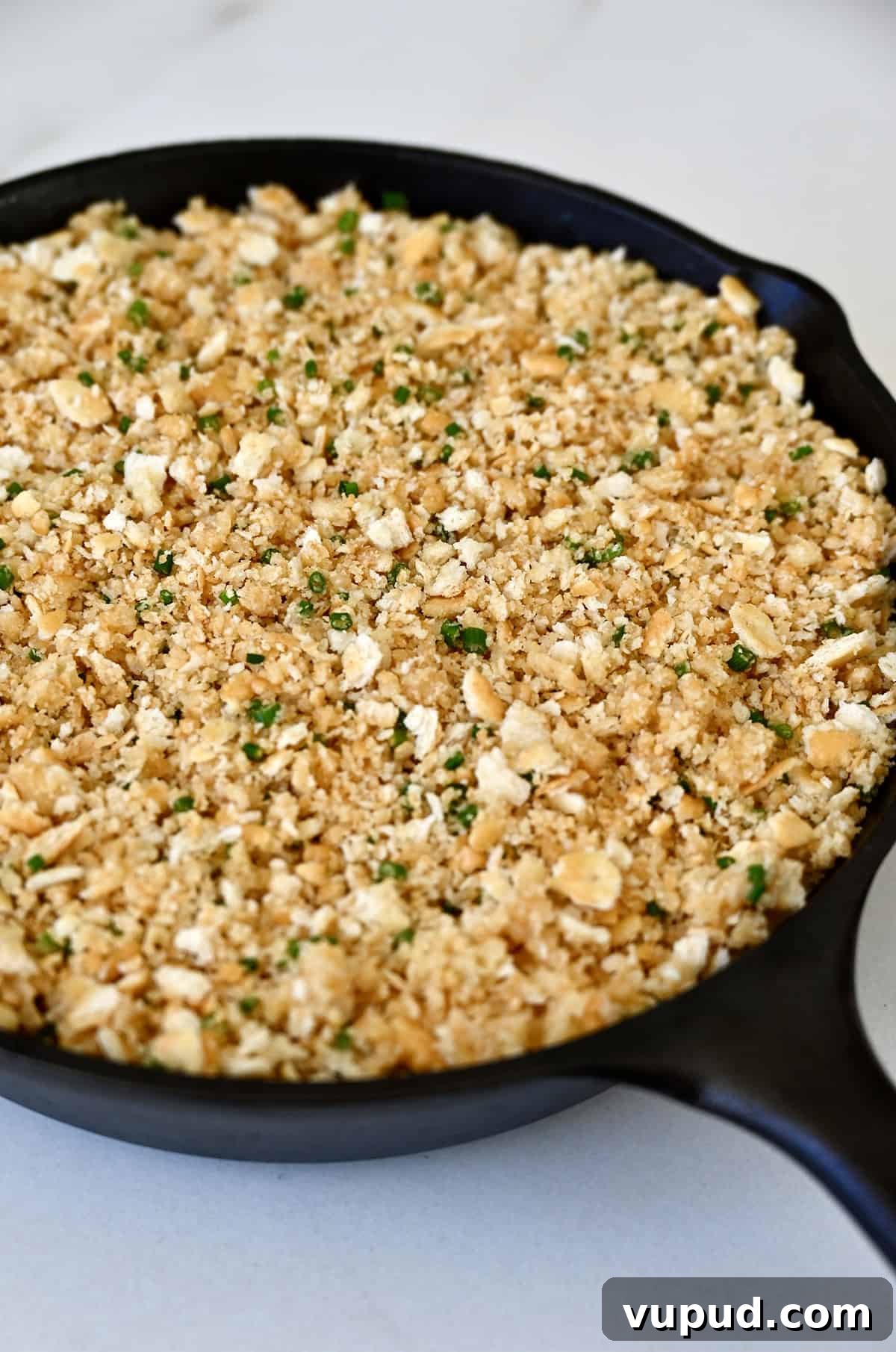 Creamy Jalapeño Popper Dip Recipe for Parties and Game Day 10 Crushed crackers atop jalapeño dip in a cast iron skillet.