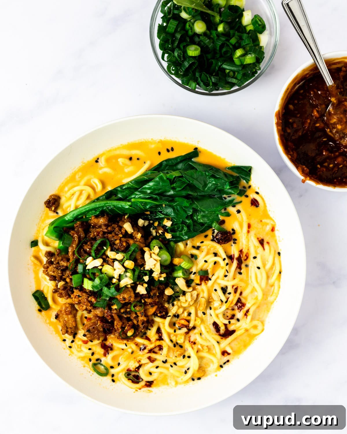 Spicy Sesame Tantanmen Ramen Recipe for Authentic Flavor 9 tantanmen ramen alongside bowls of toppings.