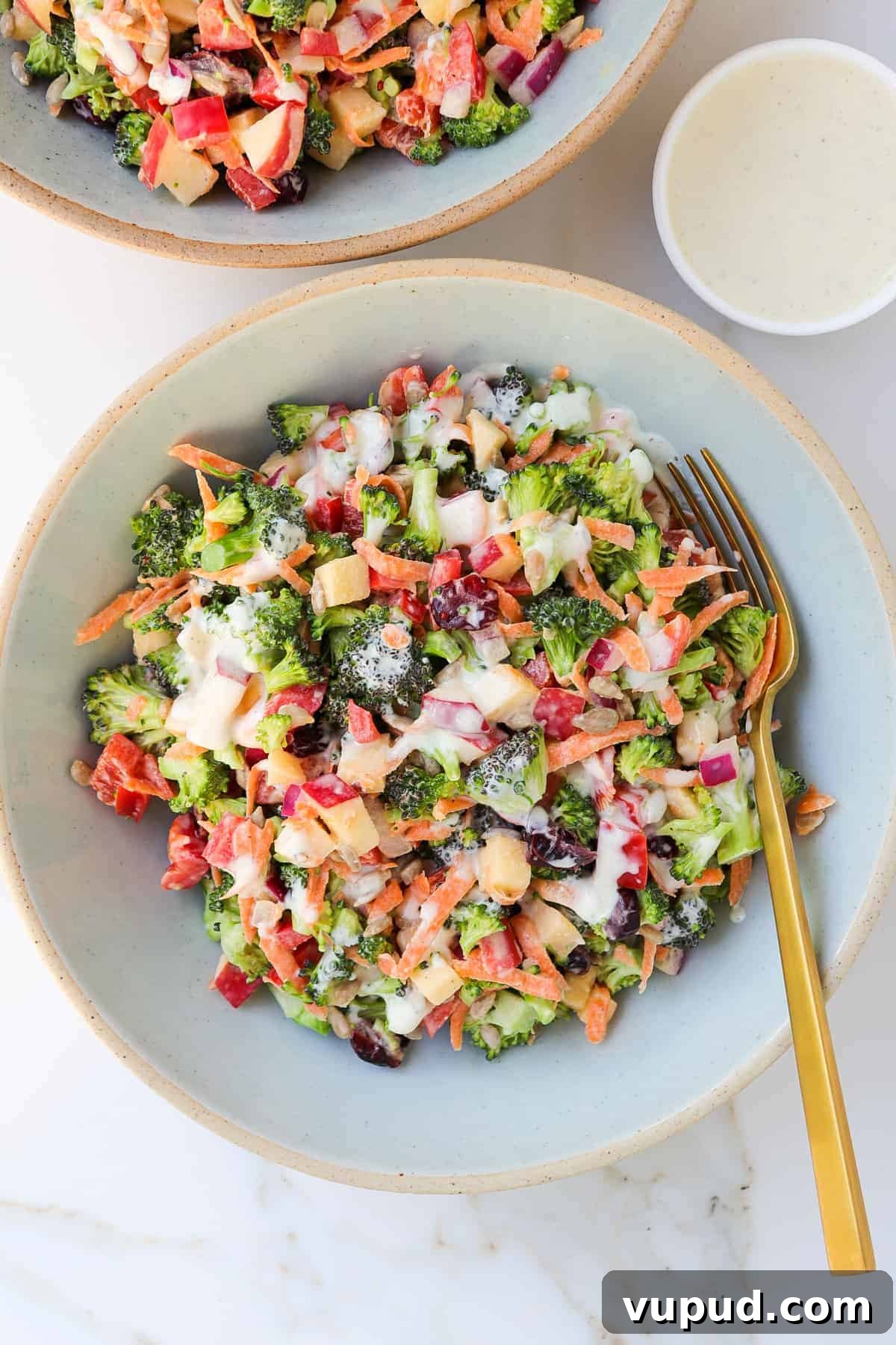 Crispy Broccoli Crunch Salad with Bacon & Tangy Dressing 2 Broccoli salad in a bowl with a fork and extra tahini dressing in a little dish.
