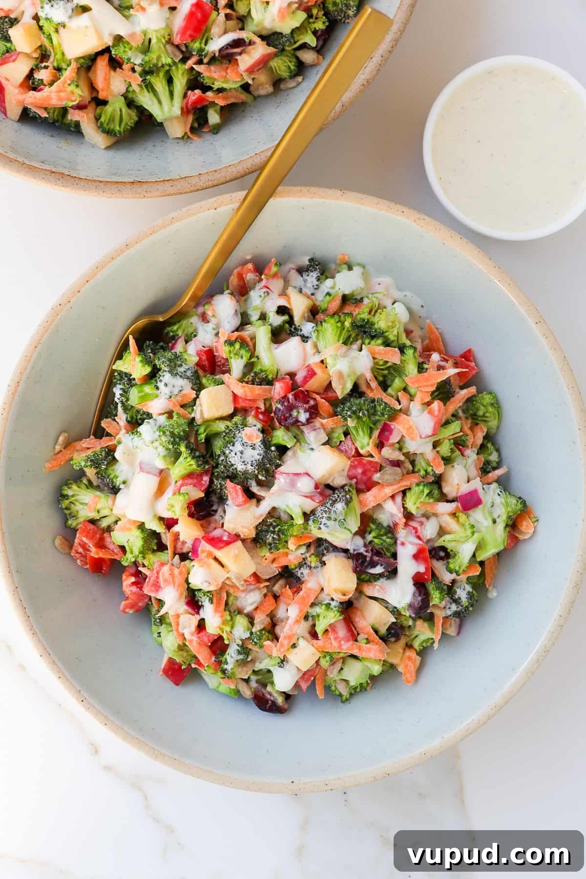 Crispy Broccoli Crunch Salad with Bacon & Tangy Dressing 7 Broccoli crunch salad in a bowl with a gold fork.