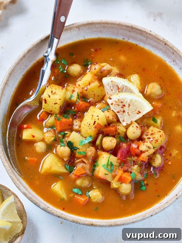 $80 Weekly Meal Plan: 5 Budget-Friendly Dinners for the Week 11 A spoon scooping chickpeas and vegetable soup from a bowl.