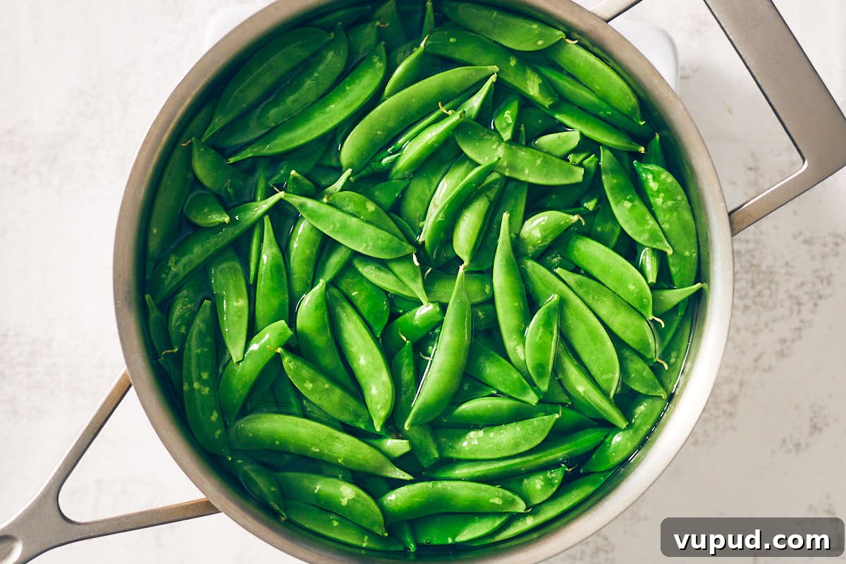 Crisp Snap Pea Salad with Whipped Feta and Lemon Vinaigrette 9 Boiling sugar snap peas in a pot of hot water.