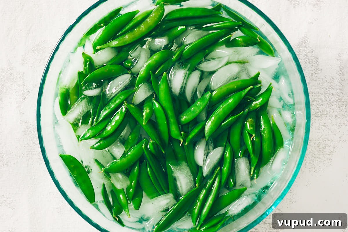 Crisp Snap Pea Salad with Whipped Feta and Lemon Vinaigrette 10 Blanching sugar snap peas in a bowl of ice water after boiling.