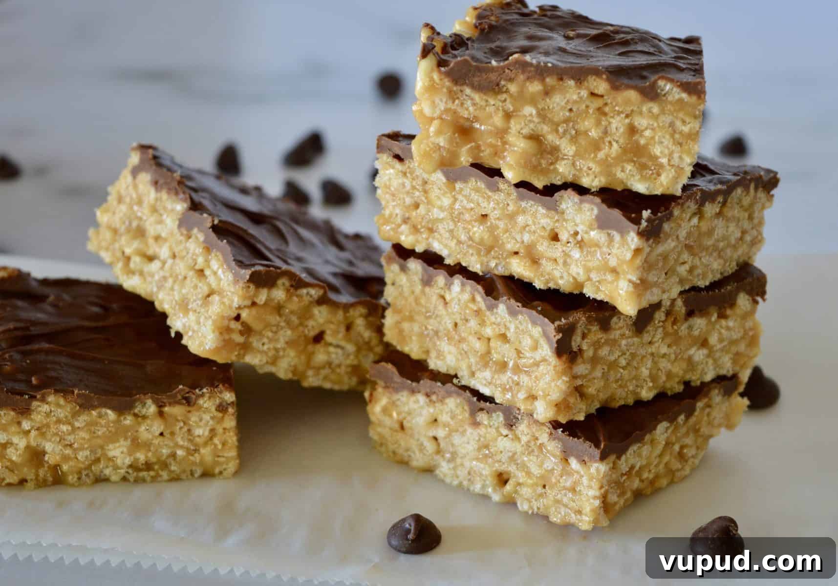 Caramel Peanut Butter Krispie Bars Without Marshmallows 2 Caramel Peanut Butter Krispies staked on a white countertop.