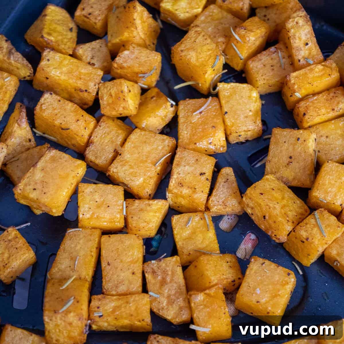 Crispy Air Fryer Butternut Squash Recipe: Quick Roasted Cubes 7 Cubed squash at the bottom of an air fryer basket cooked.