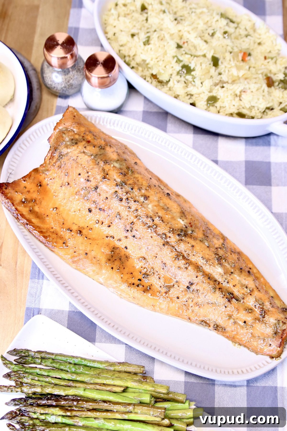 maple glazed salmon with asparagus and rice pilaf dinner. platter of salmon filet, asparagus, bowl of rice.