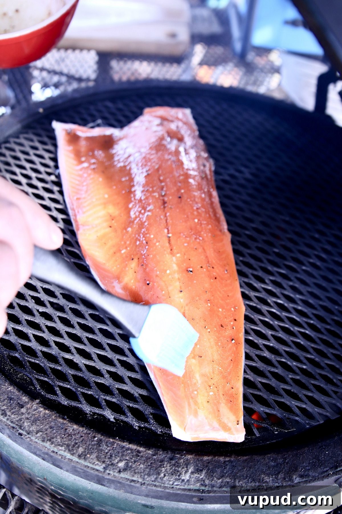 how to glaze grilled salmon - easy maple glaze recipe brushing glaze over salmon filet on a grill.