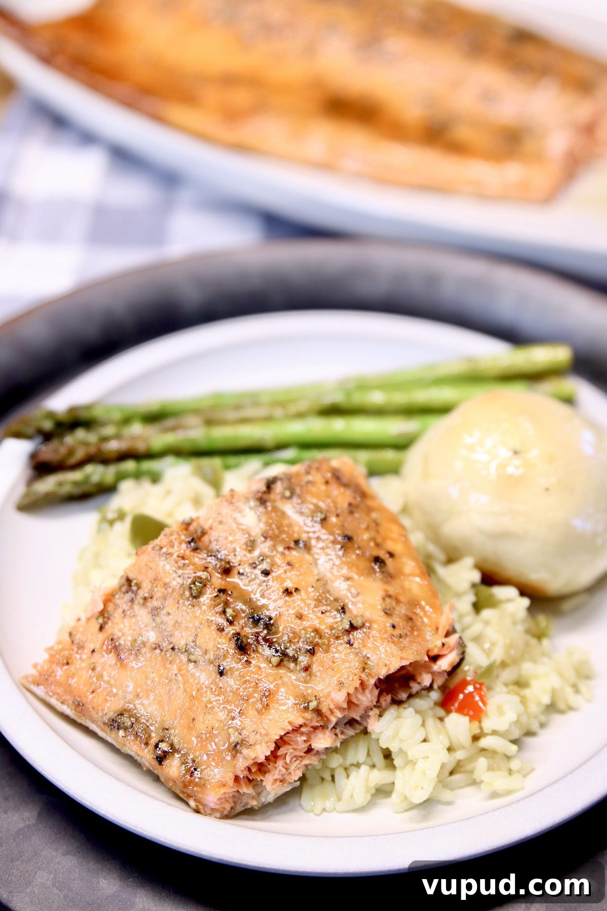 grilled salmon recipe with maple and pepper glaze grilled salmon plated with rice, roll and asparagus.