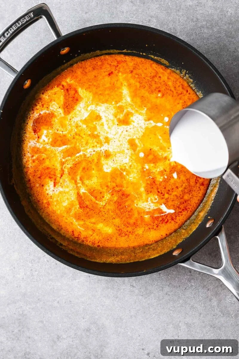 Authentic Thai Red Curry with Fish: Quick Flavorful Recipe 7 Adding full-fat coconut milk to the red curry sauce.