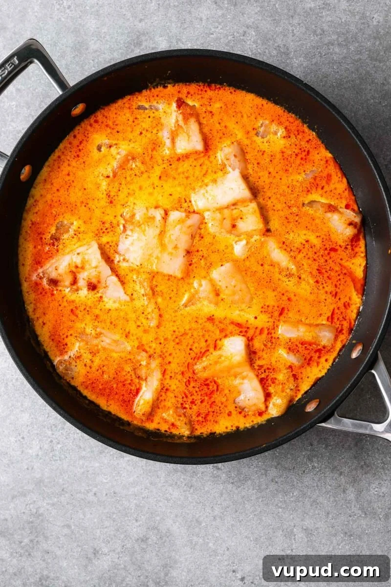 Authentic Thai Red Curry with Fish: Quick Flavorful Recipe 8 Large even-sized chunks of raw white fish fillets in a red curry coconut sauce.
