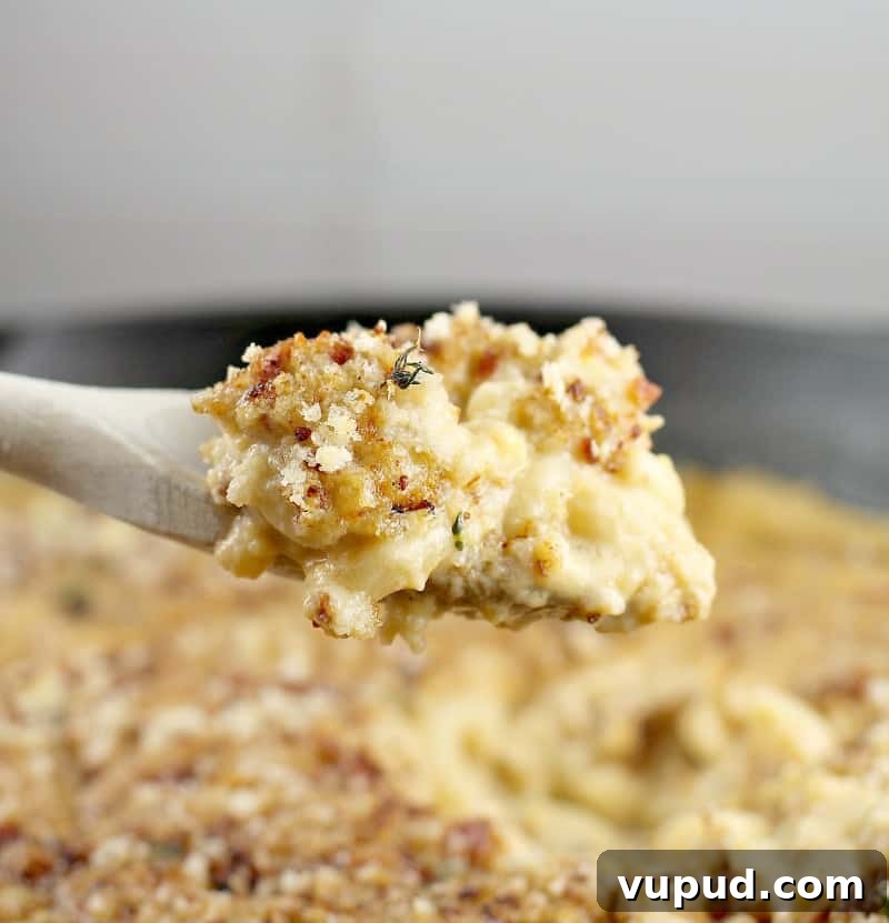 Garlic, Bacon & Beer Macaroni and Cheese Recipe 11 side view of a wooden spoon scooping up a bit of the beer mac and cheese