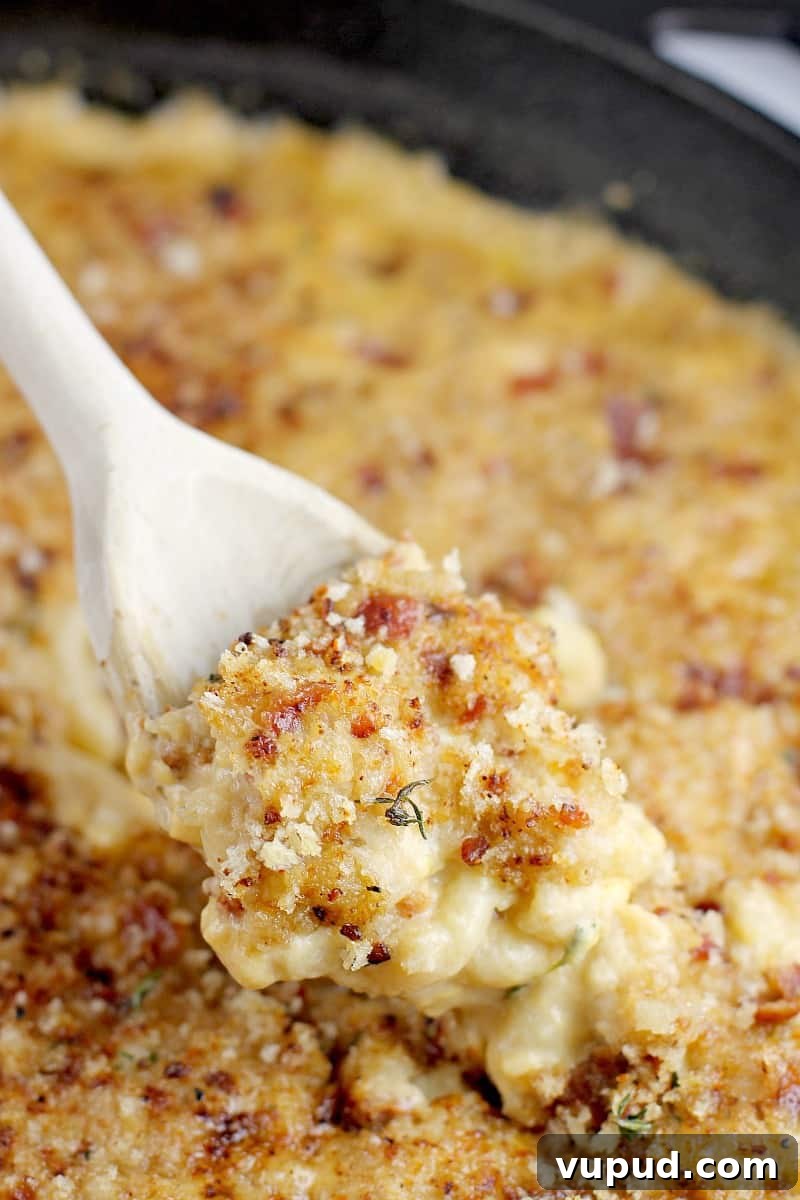 Garlic, Bacon & Beer Macaroni and Cheese Recipe 3 side view of a wooden spoon scooping up a bit of the beer mac and cheese