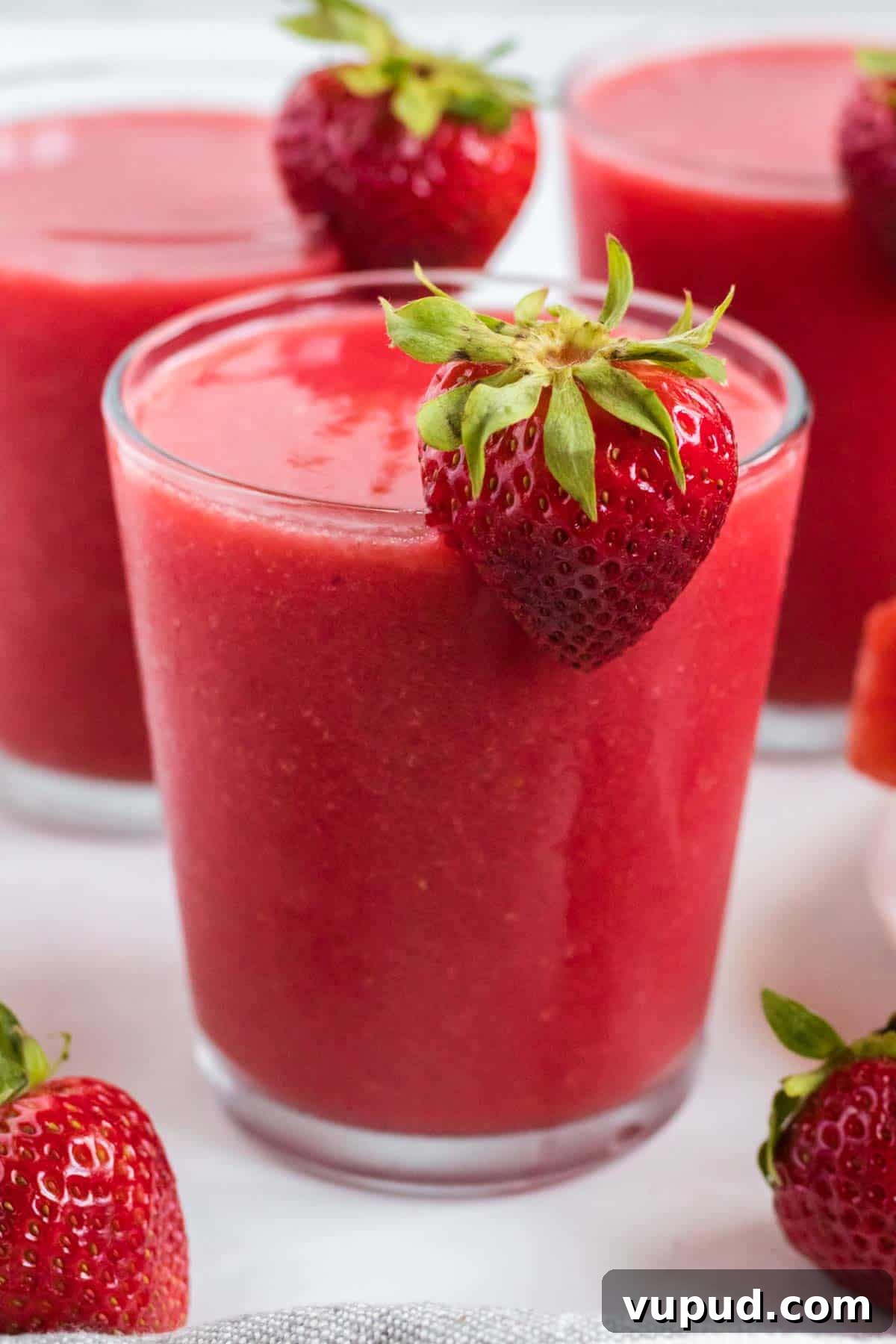 Refreshing Strawberry Watermelon Smoothie Recipe for Summer 2 strawberry watermelon smoothie in a clear glass with a strawberry on the rim