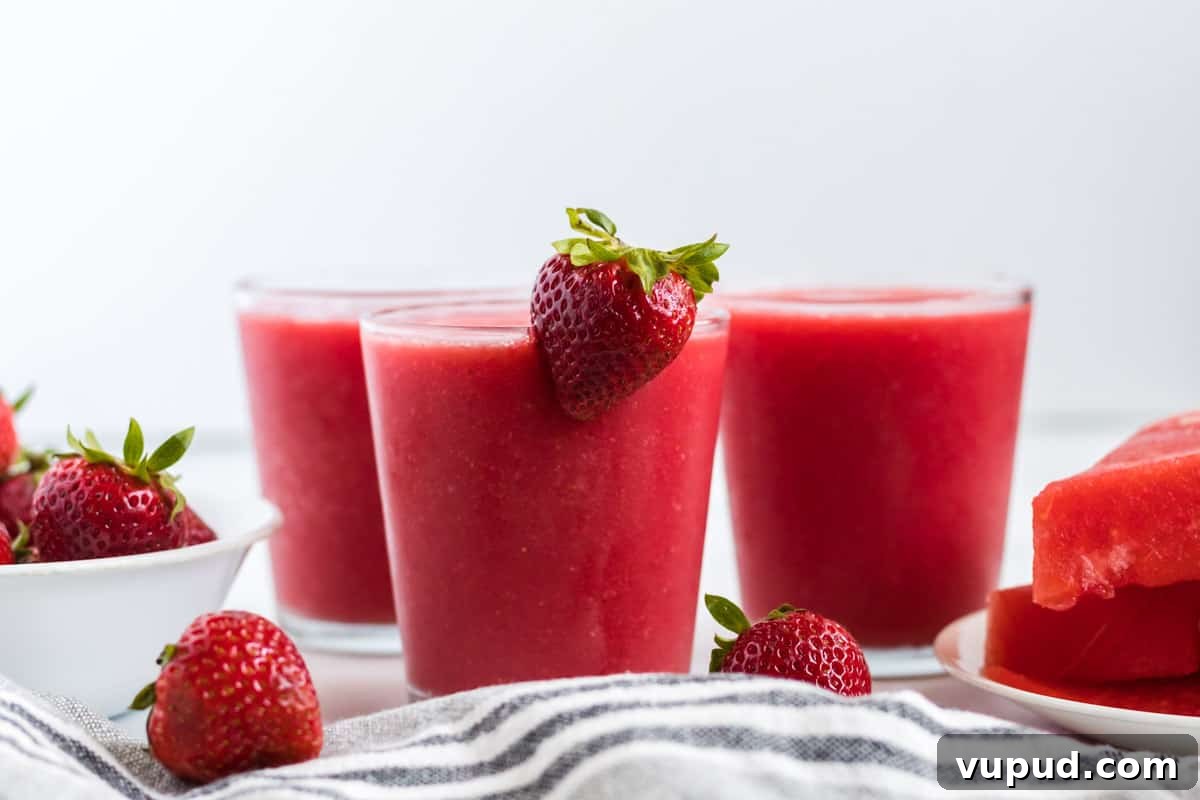 Refreshing Strawberry Watermelon Smoothie Recipe for Summer 7 strawberry watermelon smoothie in a clear glass with a strawberry on the rim