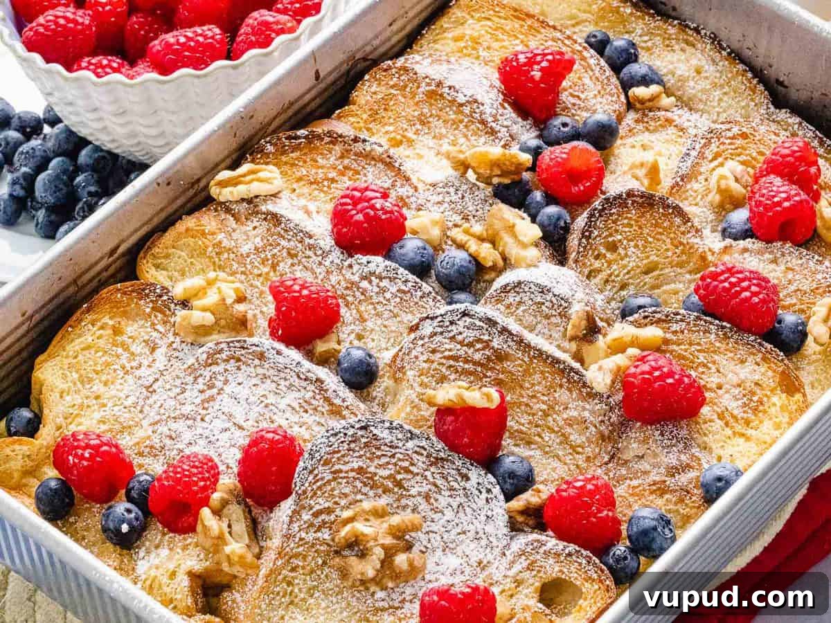 Make-Ahead Baked French Toast Casserole Recipe 4 Baked french toast casserole with cinnamon, blueberries, raspberries in a baking dish.