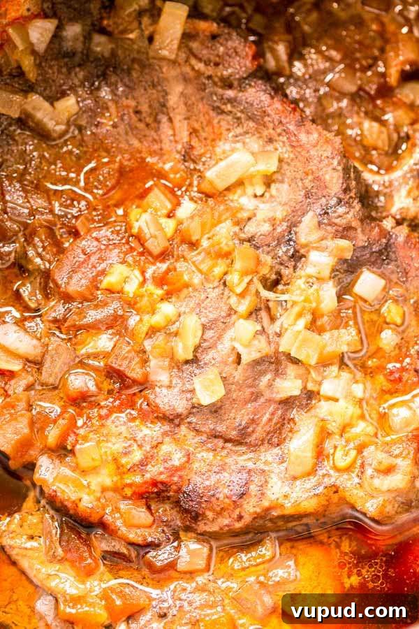 Juicy Pork Shoulder Steak in the Instant Pot: Quick Tender Recipe 3 Close up of a juicy pork shoulder steak with onion prepared in an Instant Pot.