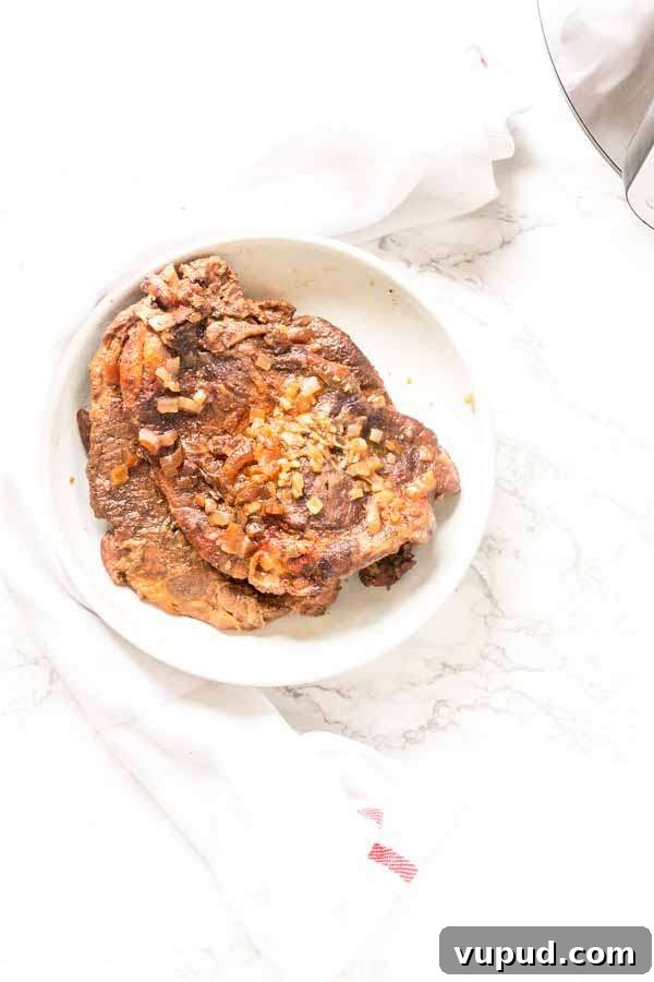 Juicy Pork Shoulder Steak in the Instant Pot: Quick Tender Recipe 5 Instant Pot pork shoulder steak on a white plate, ready to be served for dinner.
