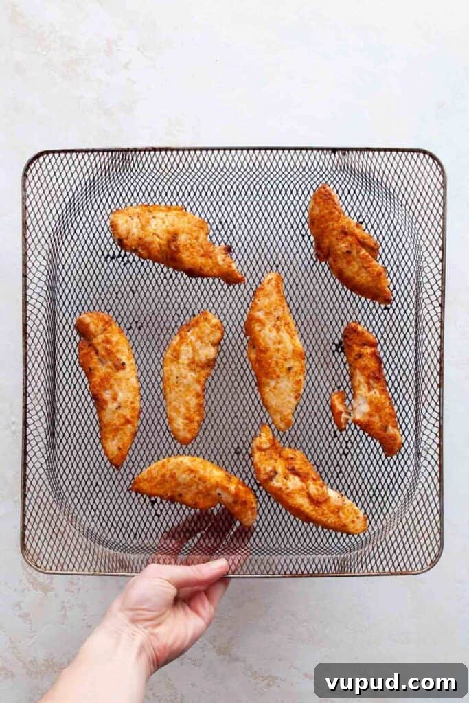 Crispy Air Fryer Chicken Tenders Without Breading 7 cooked chicken tenders without breading in an air fryer basket