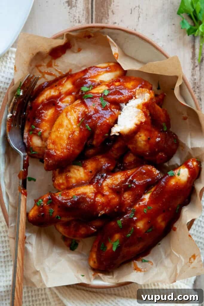 Crispy Air Fryer Chicken Tenders Without Breading 8 Bite shot of an air fryer chicken tender to show moist and juicy inside