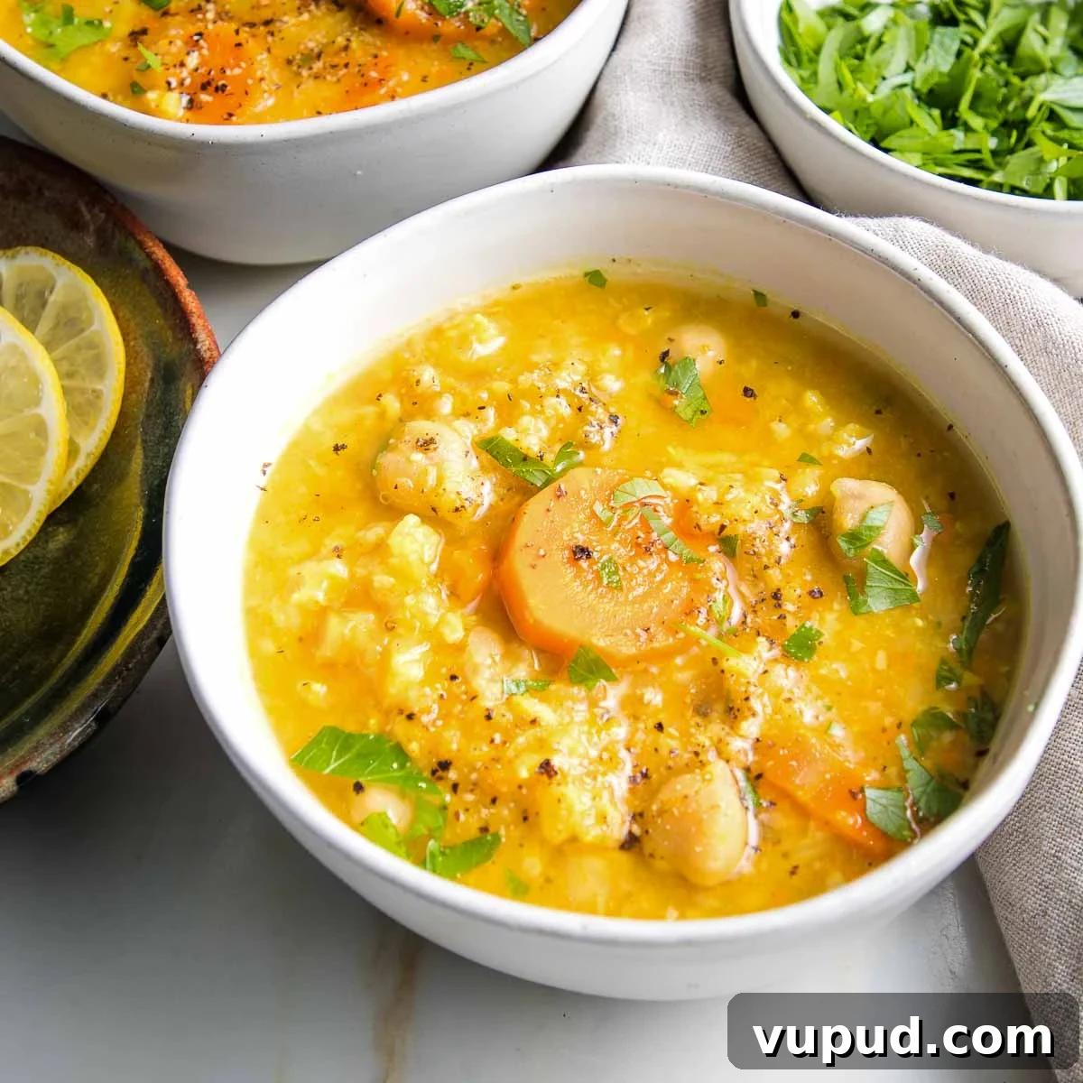 Lemony Vegan Chickpea and Rice Soup Recipe 3 White bowl filled with chickpea rice soup.