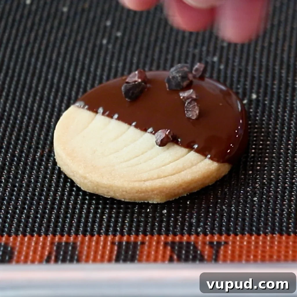 Classic Buttery Shortbread Cookies Recipe for Perfect Cookies 28 sprinkling cacao nib on top of dark chocolate on a cookie