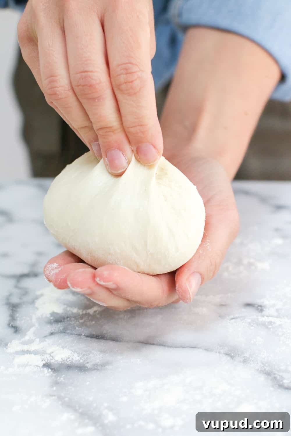 72-Hour Pizza Dough Recipe from Baking Steel 14 pinching the top of the pizza dough ball
