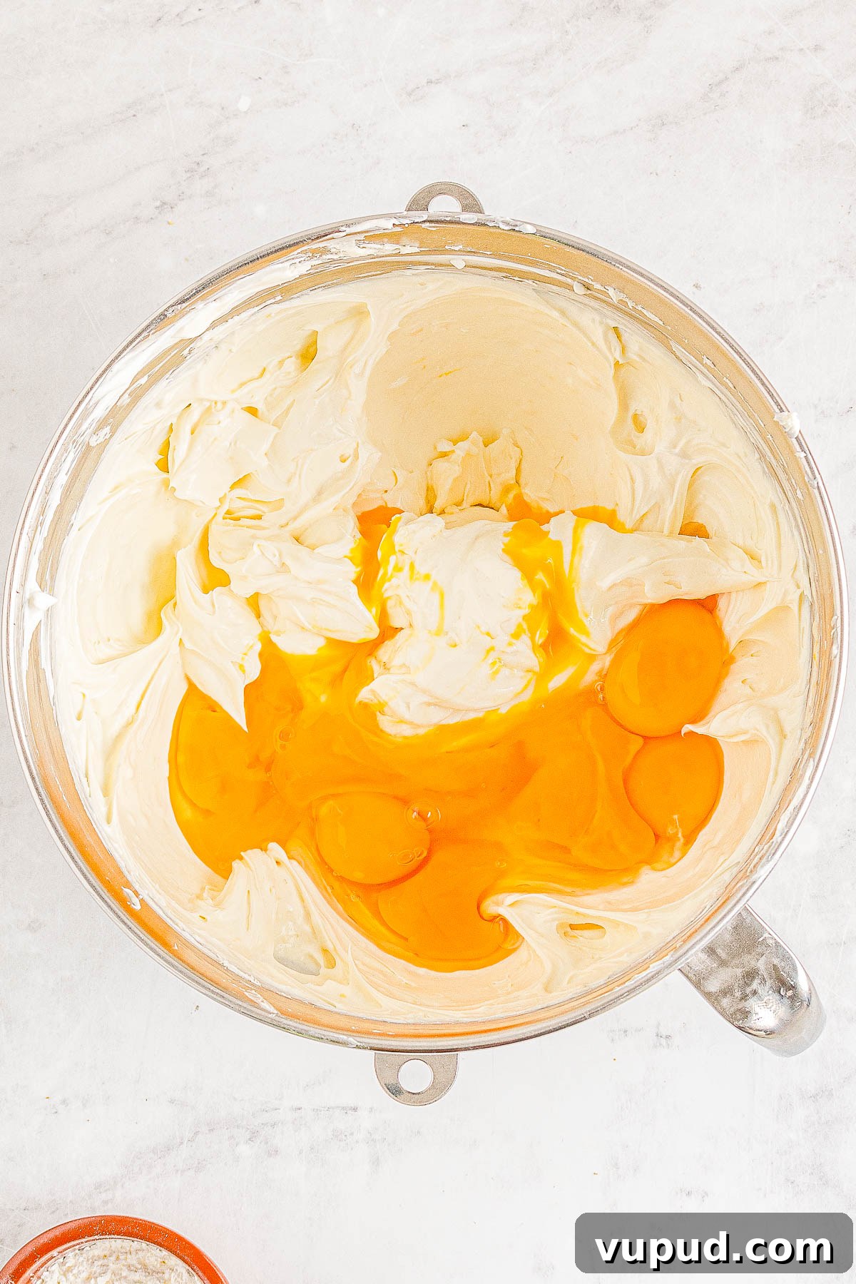 Classic New York Cheesecake Recipe: Creamy Oven-Baked Slice 14 Eggs being added to cheesecake filling.