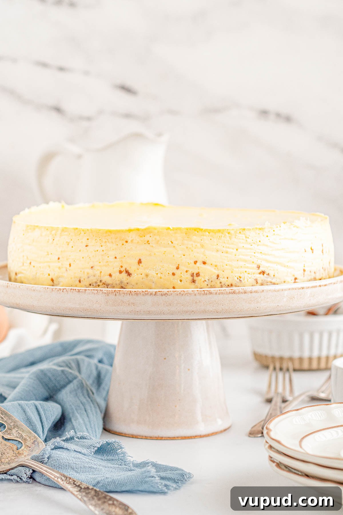 Classic New York Cheesecake Recipe: Creamy Oven-Baked Slice 19 A New York-style cheesecake on a cake stand.