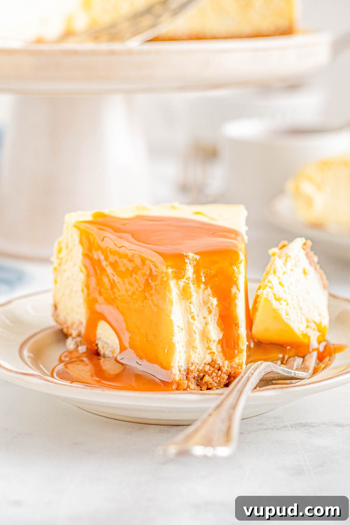 Classic New York Cheesecake Recipe: Creamy Oven-Baked Slice 20 A slice of New York cheesecake topped with caramel sauce with a fork holding a bite.
