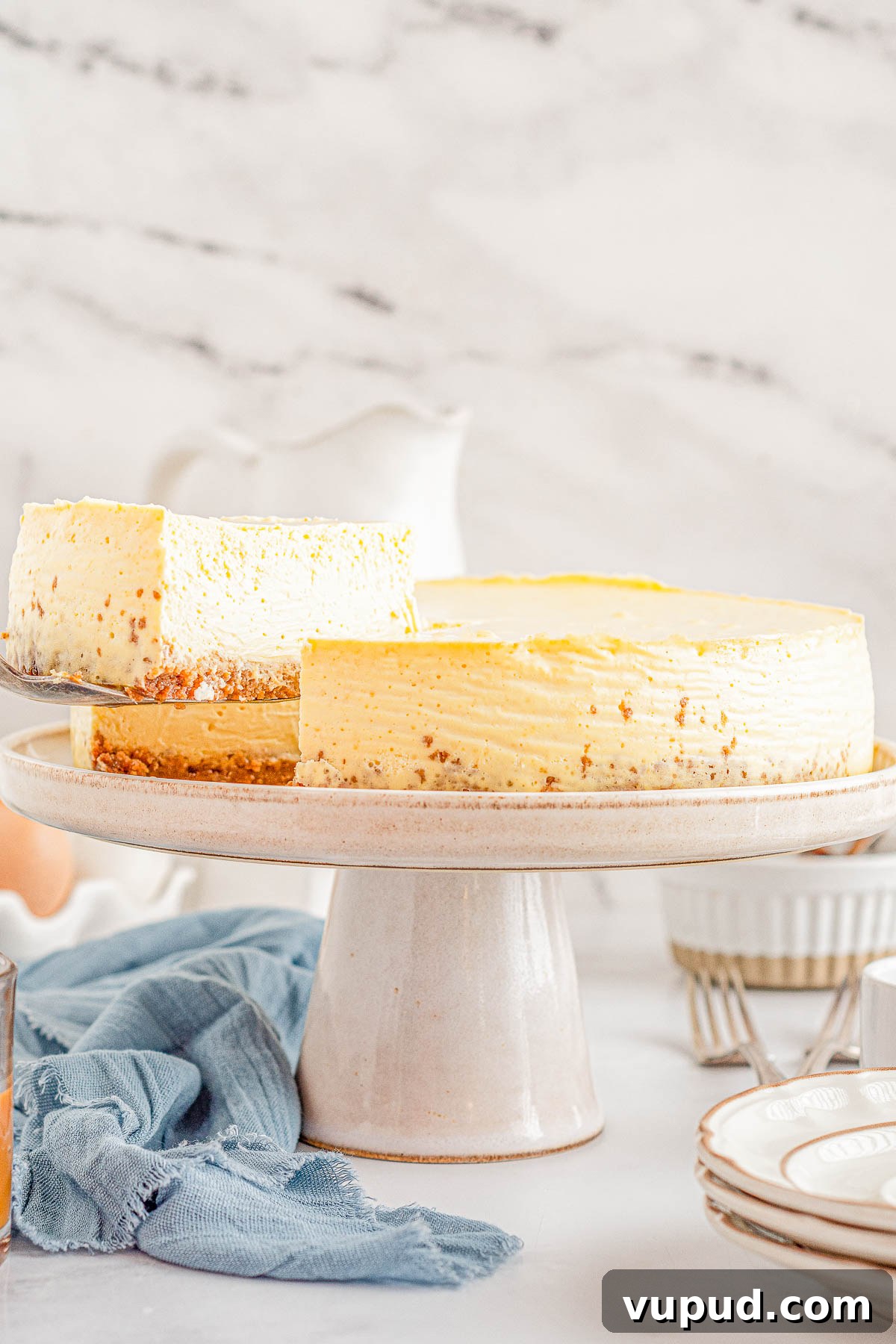 Classic New York Cheesecake Recipe: Creamy Oven-Baked Slice 3 A slice of cheesecake being lifted from a cake stand.