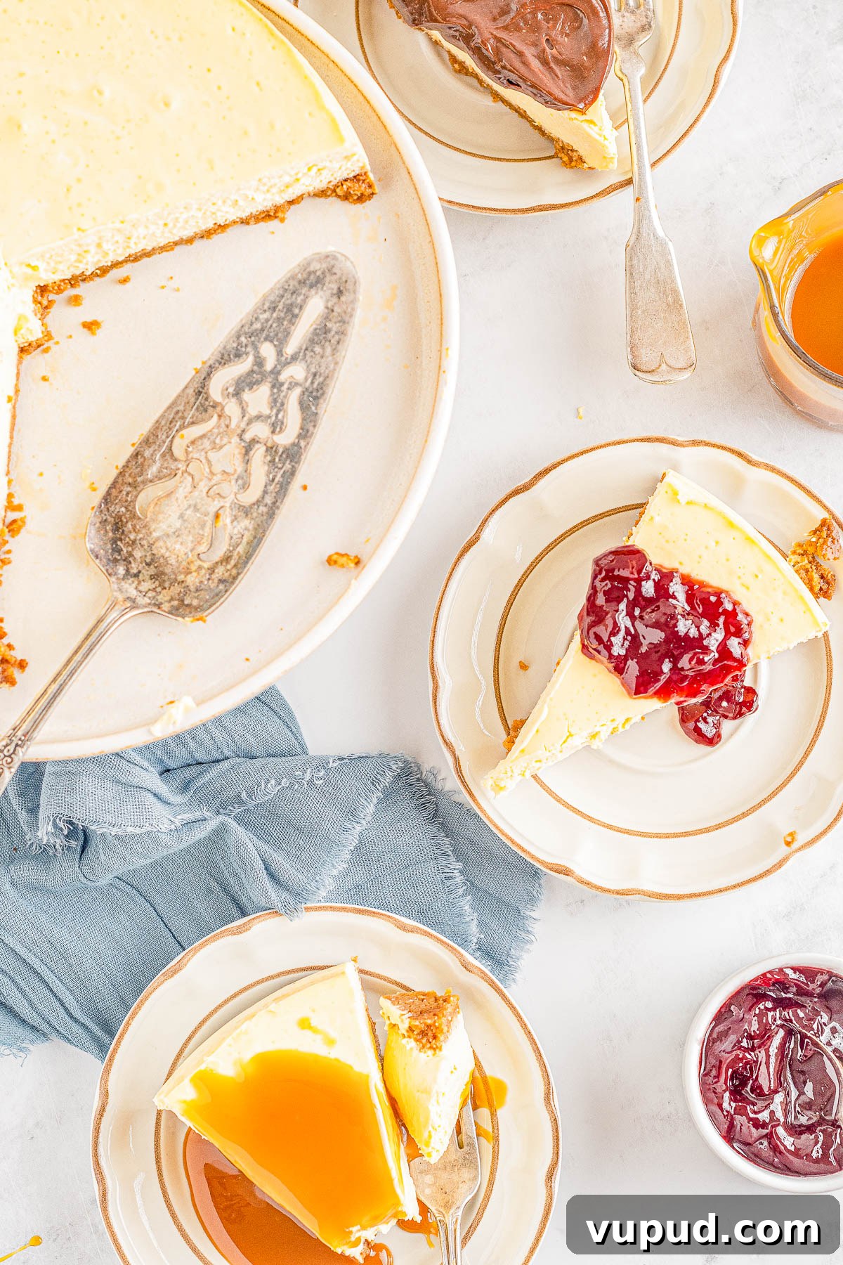 Classic New York Cheesecake Recipe: Creamy Oven-Baked Slice 21 Overhead image of New York cheesecake slices topped with fruit jam and caramel sauce.