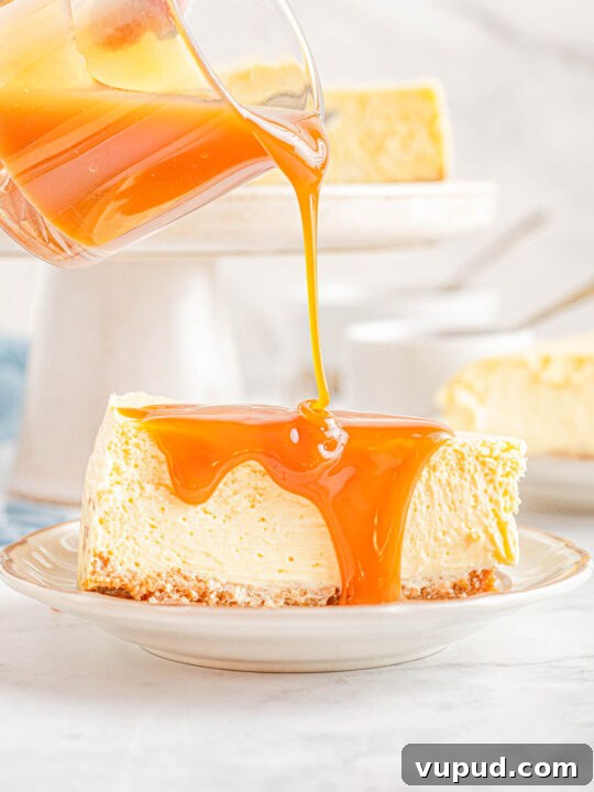 Classic New York Cheesecake Recipe: Creamy Oven-Baked Slice 26 Caramel sauce being drizzled over a slice of New York cheesecake.