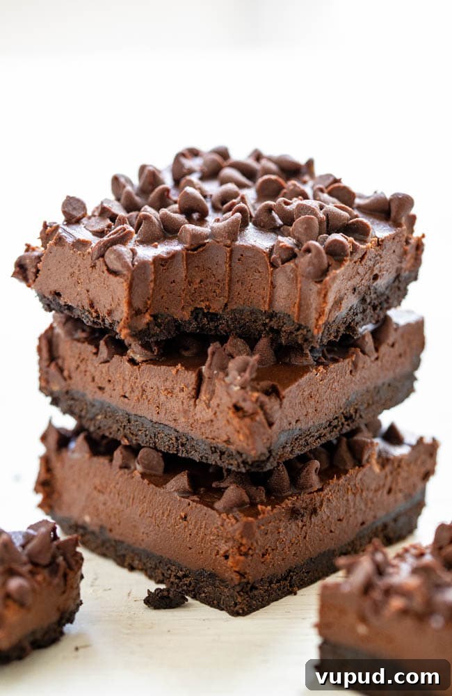 Classic New York Cheesecake Recipe: Creamy Oven-Baked Slice 33 A stack of three Death by Chocolate No-Bake Cheesecake Bars, the top bar missing a bite.