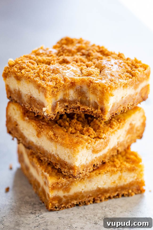 Classic New York Cheesecake Recipe: Creamy Oven-Baked Slice 34 a stack of three butterscotch cheesecake bars. the top bar has a bite missing.